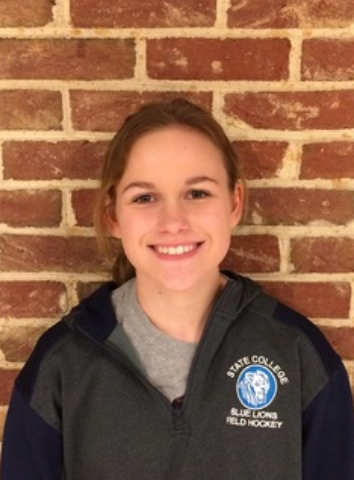 Katelyn Sullivan smiles wearing her blue lions field hockey jacket