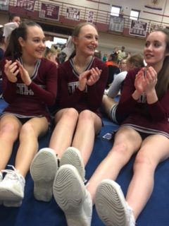 Captains Carsyn Schafer and Olivia Sneath with teammate Kelsey Chandler at awards ceremony during the cheerleading competition.