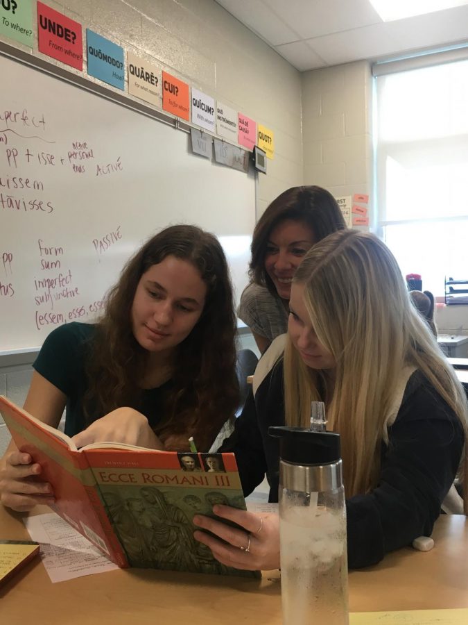  Latin teacher, Jennifer Schreiber, observes Latin 2 students Annie Gustafson and Hope Neal during a class activity. Gustafson (pictured on the left), who went on the field trip, said , “This experience demonstrates how studying the classics extends far beyond the ancient Greeks and Roman.”