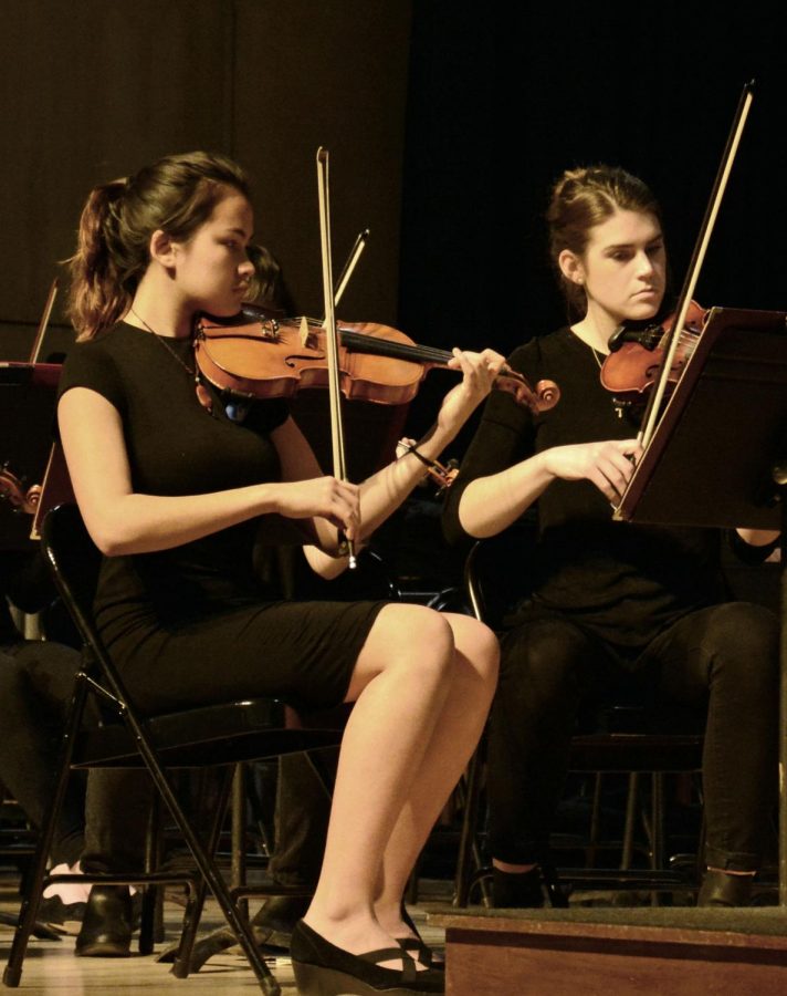 First violinist, Maria Bressan (pictured on the left), plays her violin during the winter orchestra concert on December 10th. Bressan details why she loves playing the violin. “I think the violin has the greatest range of color out of all instruments, so it gives the players a lot of freedom of expression.”




