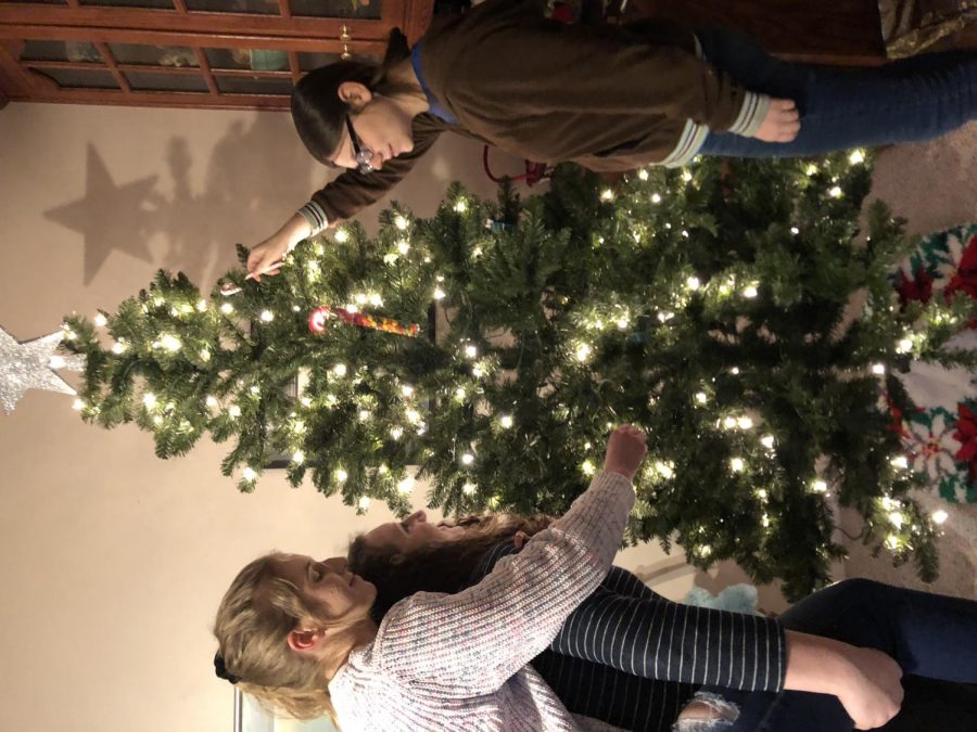 Freshman, Maddie O’Hara, junior Genevieve Miller, and junior Emily Felice decorate a Christmas tree. Many families consider Christmas  tree decorating a tradition. I remember countless times that my family spent a whole day cutting down the perfect Christmas tree that all of us liked said junior Emily Felice.