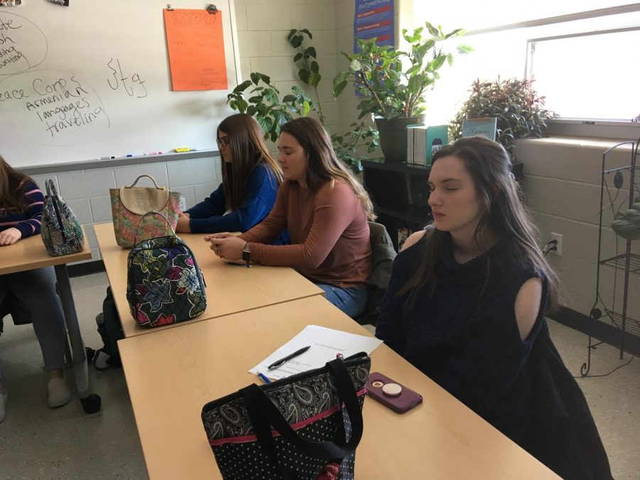 From right to left, juniors Caylee Thompson, Taylor Balboni, and Lily Maxwell practice mindfulness during an English class. Mindfulness can be used in class or life to reduce levels of anxiety and stress. “I like that it gives us time to prepare before class and relax,” said Thompson.
