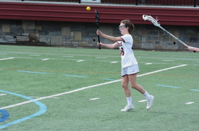 Maya Ikenberry throwing a pass to a fellow Little Lions lacrosse player. For me, lacrosse takes away any stress I have because I look forward to something I love doing every day, and I go into practice knowing I will be doing something I love, Ikenberry said.