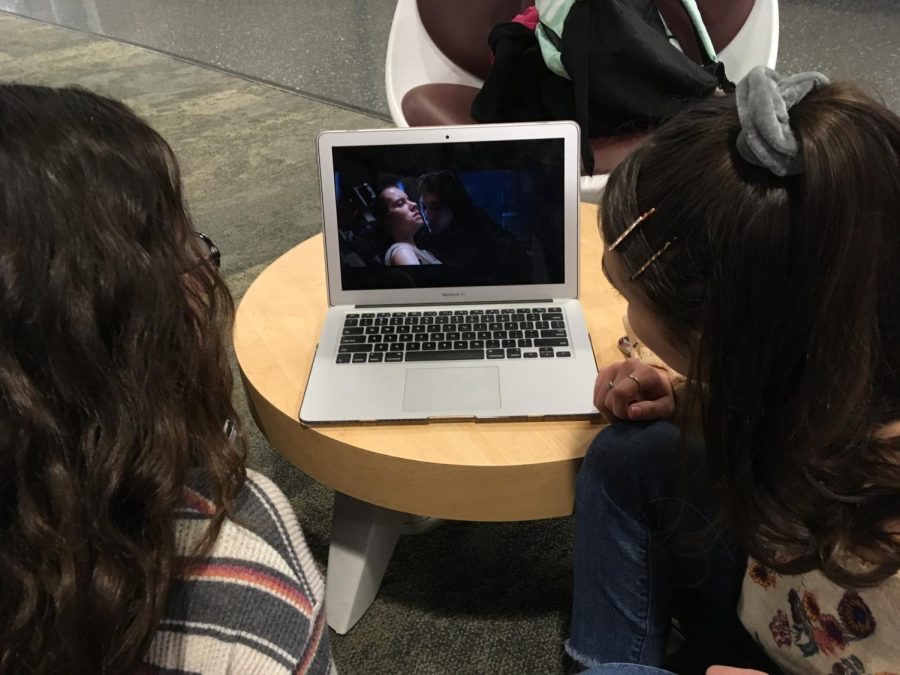 While spending free time at school, freshman Clarissa Theiss and junior Ella Simpson watch part of  Star Wars: The Force Awakens. Science-fiction movies and shows have been defying gender roles and breaking stereotypes for decades. “I think that sci-fi films like Star Wars or action movies are more valuable for girls to watch; they are realistic in the sense that they empower women,” Simpson said.
