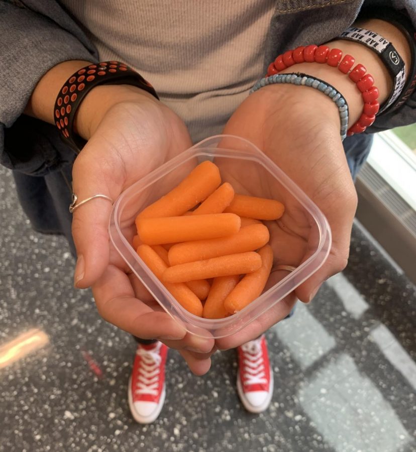 A student holding carrots. Meant to signify the literacy of healthy eating,  Dr. Anne Becker recommends eating healthy foods. “Schools should start as early as elementary school implementing and teaching health literacy to children,” Dr. Becker said. 