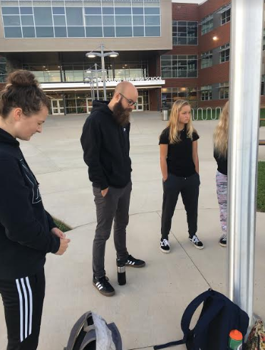 Students, youth pastors and leaders gathered outside of State Highs flag pole, praying. 