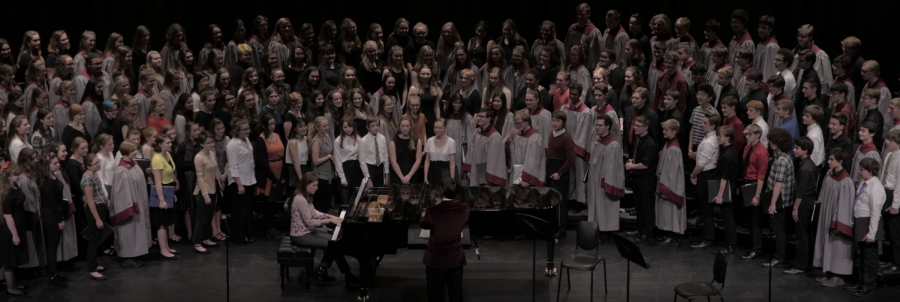 All+choirs+smile+after+receiving+a+look+of+pride+from+director+Erik+Clayton+after+their+combined+performance+of+%E2%80%9CAve+Verum%E2%80%9D+by+W.A.+Mozart.+This+is+a+song+that+Clayton+loves+the+choirs+to+perform+together+and+they+performed+it+at+the+dedication+ceremony+earlier+this+year.+%E2%80%9CHearing+the+different+dynamics+with+everyone+on+stage+is+so+interesting+and+hearing+so+many+people+in+the+different+parts+was+so+cool%2C%E2%80%9D+Jaqueline+Lawrence%2C+sophomore%2C+said.+