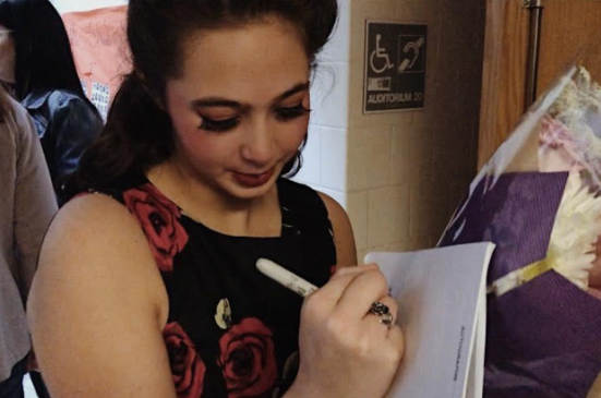 Bella Poher, actress of Rosie, signing a playbill of an audience member after the closing show. 
