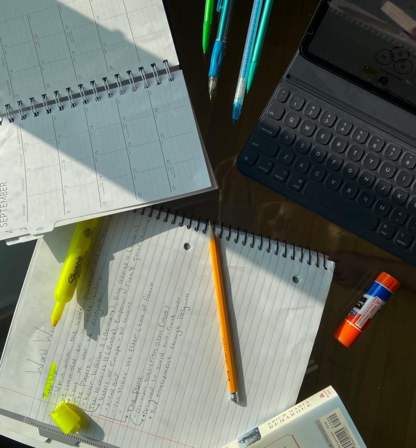 Pencils and highlighters are scattered across a notebook, planner, and desktop. A make-shift workspace for remote learning, Sept. 14, State College.