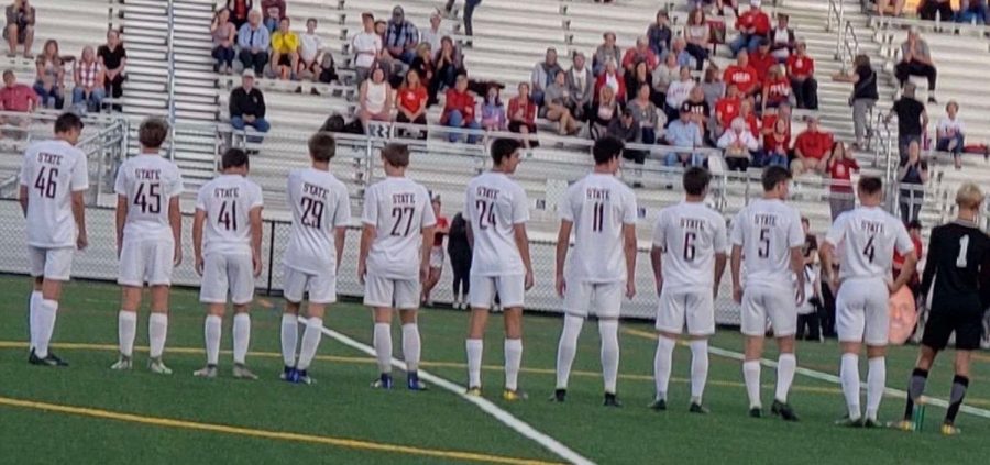 State College boys soccer players gather around the field at Cumberland Valley High School in Mechanicsburg, PA, on September 26 of 2019. Capturing the teammates embracing their jersey numbers as the national anthem plays shows the love for the sport these athletes have. 