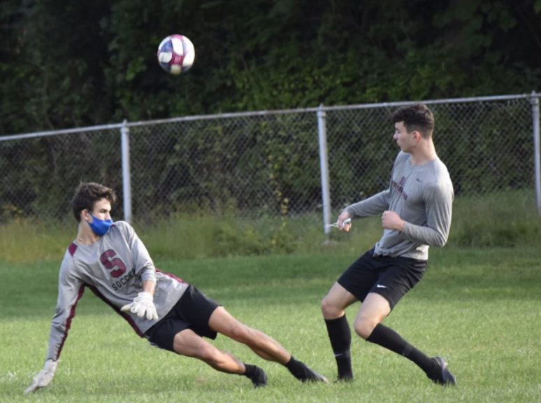 A soccer practice at Community Field in State College, PA, taken Wednesday, Aug. 9, 2020. Senior Ty Price shoots the ball at Sasha Mohoruk, senior and varsity goalie.