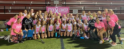 State High Field Hockey team after their Stick It To Cancer game on Oct. 6 in front of the Stick It To Cancer sign.