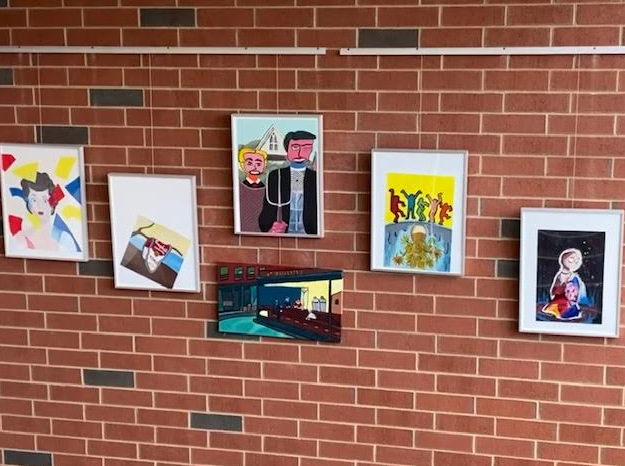 Student artwork presented above the staircase. 