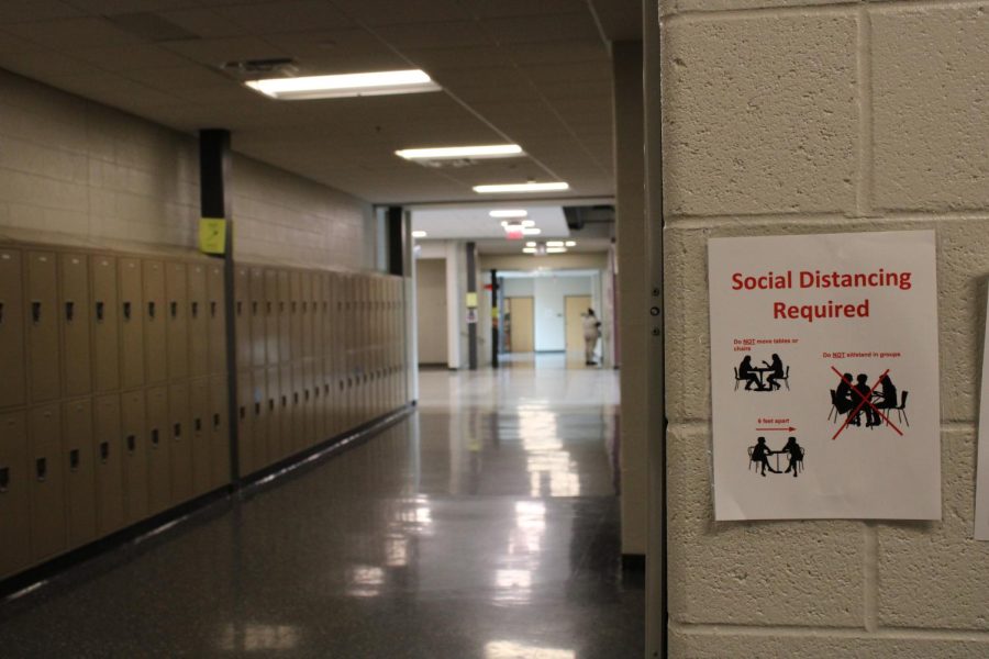A photo of a State High hallway, featuring a poster that outlines COVID safety guidelines. 