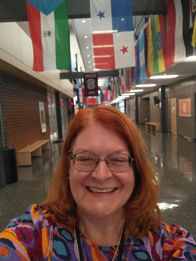 A selfie of Mrs. Gartner smiling in the main hall of State High. 
