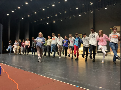 Choreographer Kat Shondeck leads students in a line dance during rehearsal. Front left to right, Hadley M. Luka D., Sacha B. Anna R., Luke M., Audrey S., Madi C., Nate R., Issac V., Ben R., Sam W., JR T., Jason P., Adaunis S., Caroline P., Ethan W.