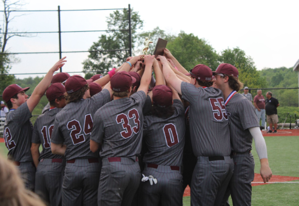 The team reaching up to touch the championship trophy. Photo by Noah Radio