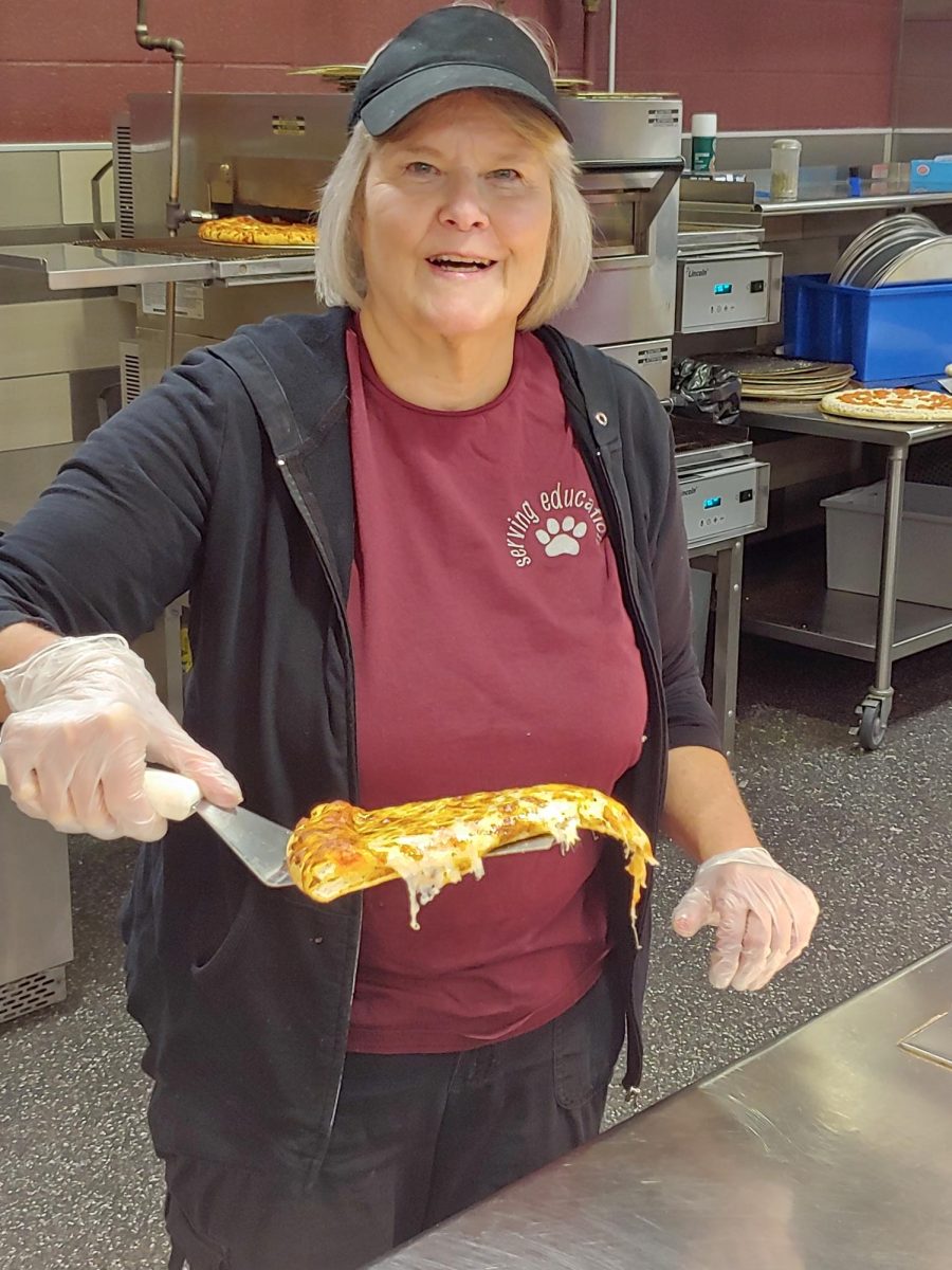 Patzer holding a slice of pizza served every day.