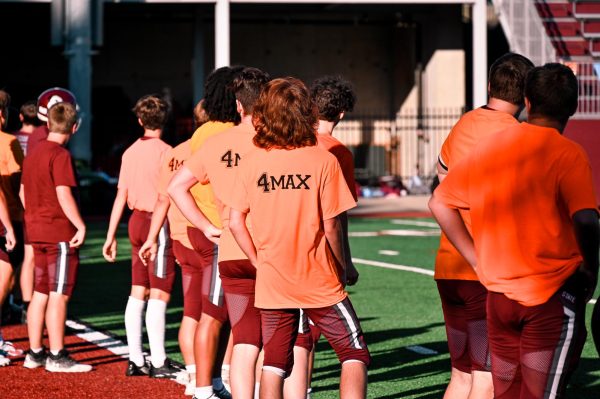 State High football players wear orange shirts during pregame to show support for Max Engle.