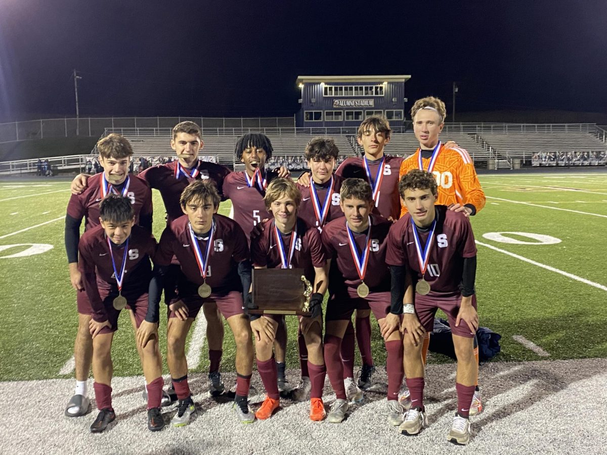 The starting lineup posing with the trophy and their medals after the game. (Front: Chase Zhou, Drew Kogelmann, Arthur Cleveland, Collin Murphy, Matias Harte; Back: Sam Cheslock, Tanner Ligetti, Solly Lubin, Gavin Zaffino, Will Kogelmann, Luke Torbic)