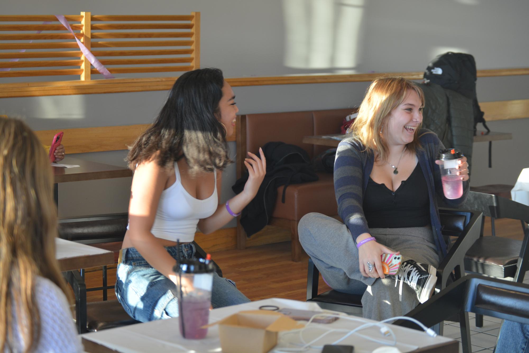 Purple Project lead Sarah Ocampo and student Jenny Heim laugh while enjoying the drink. 