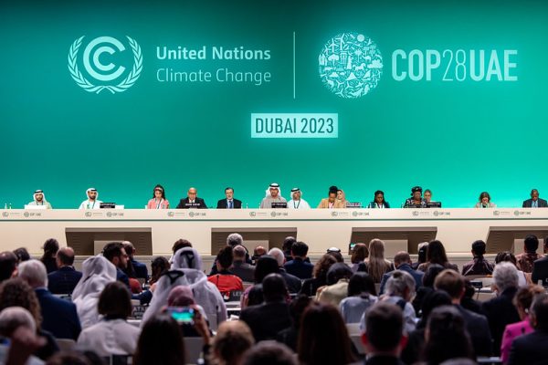 DECEMBER 13: H.E. Dr. Sultan Al Jaber, COP28 President, Simon Stiell, Executive Secretary of the UNFCCC and other delegates onstage during the Closing Plenary at the UN Climate Change Conference COP28 at Expo City Dubai on December 13, 2023, in Dubai, United Arab Emirates. 
(Creative Commons Photo by COP28 / Christopher Pike)
