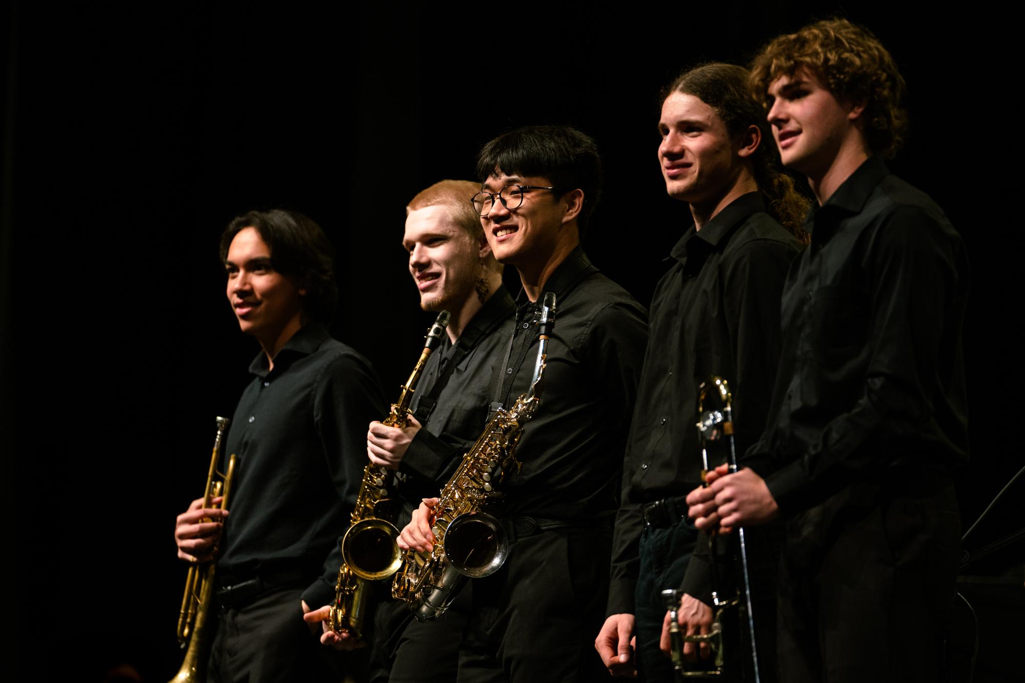 Seniors Adam Hallacher, Evan Casper, Stephen Liu, Joshua Carlson, and Arlo Nicholas stand as the audience applauds for the Jazz Band seniors at State College Jazz Night, Friday, May 17, 2024, at State High.