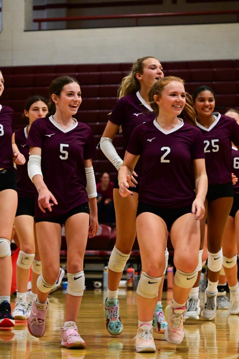 Junior Paige Adams and senior Emma Lally celebrate with their team after the win. 