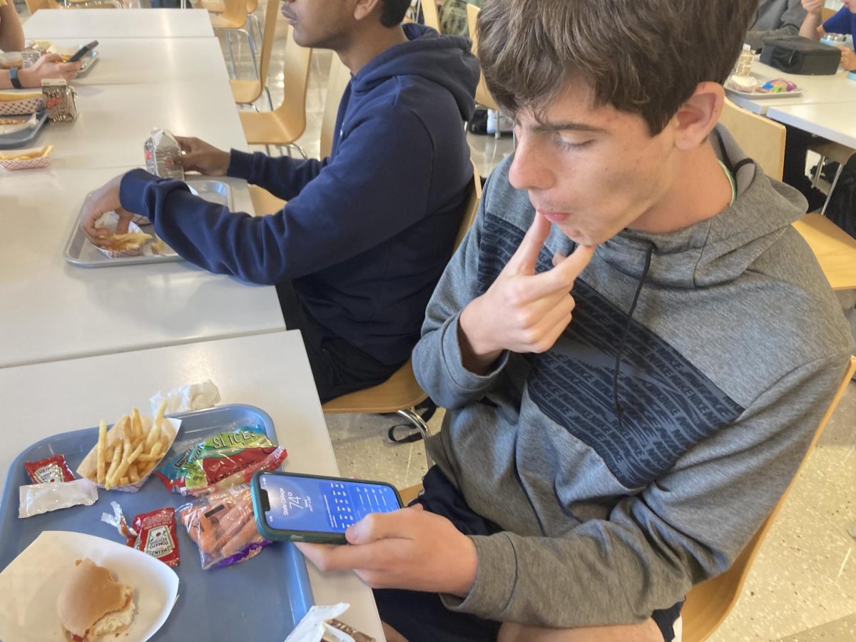 Junior Owen Viglione uses his phone during lunch.