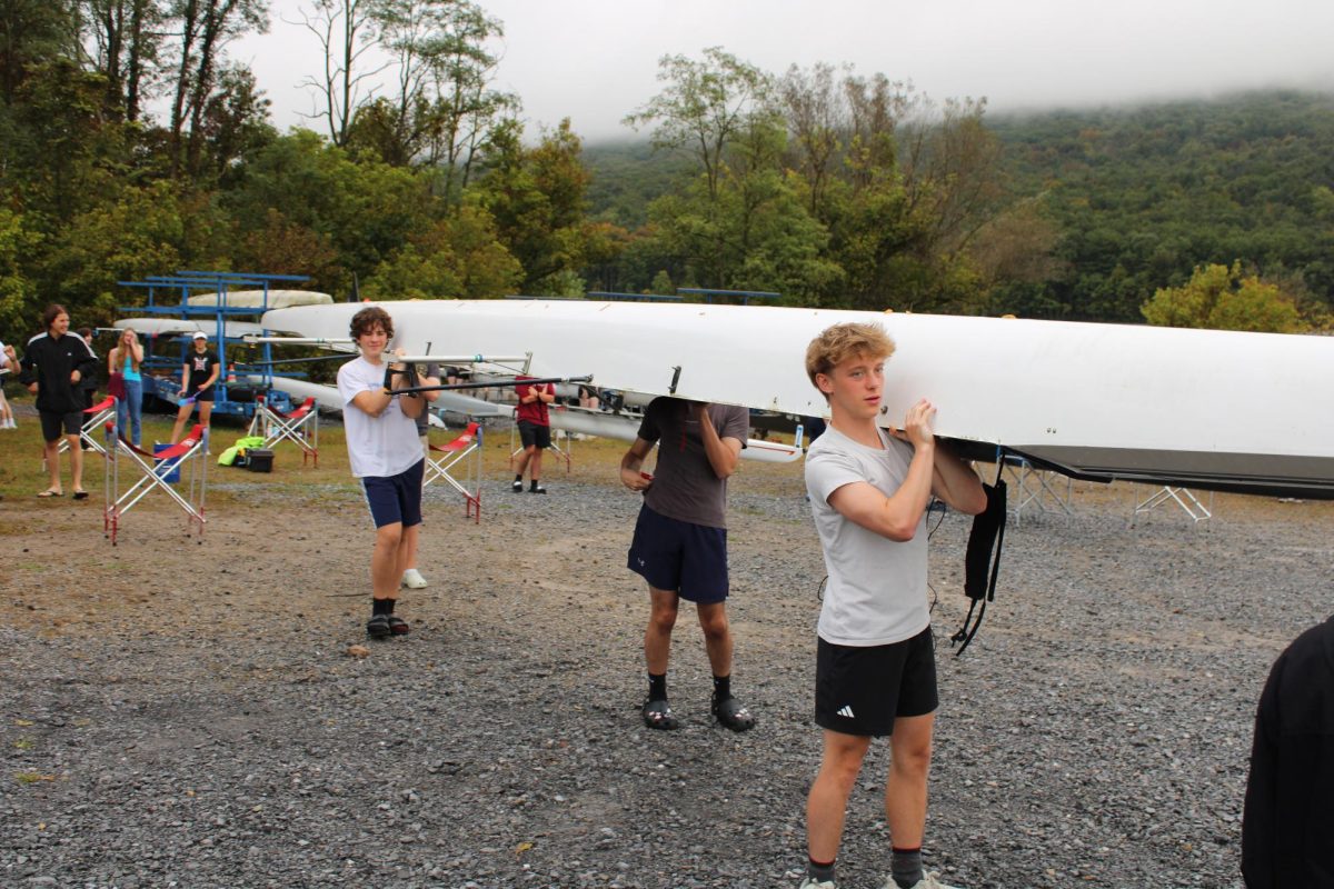 The State High novice boys 4 carry their boat to the boat launch in preparation for the regatta - September 28, 2024