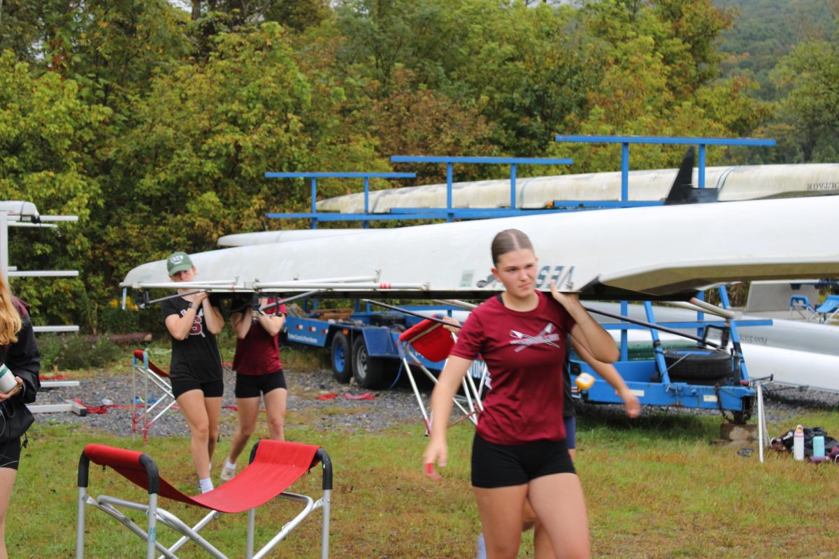 The State High girls 4 carrying their boat to the boat launch in preparation for the regatta - September 28, 2024