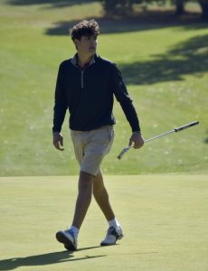 Senior Devin Farahani looks onward while walking on the green after completing a hole.