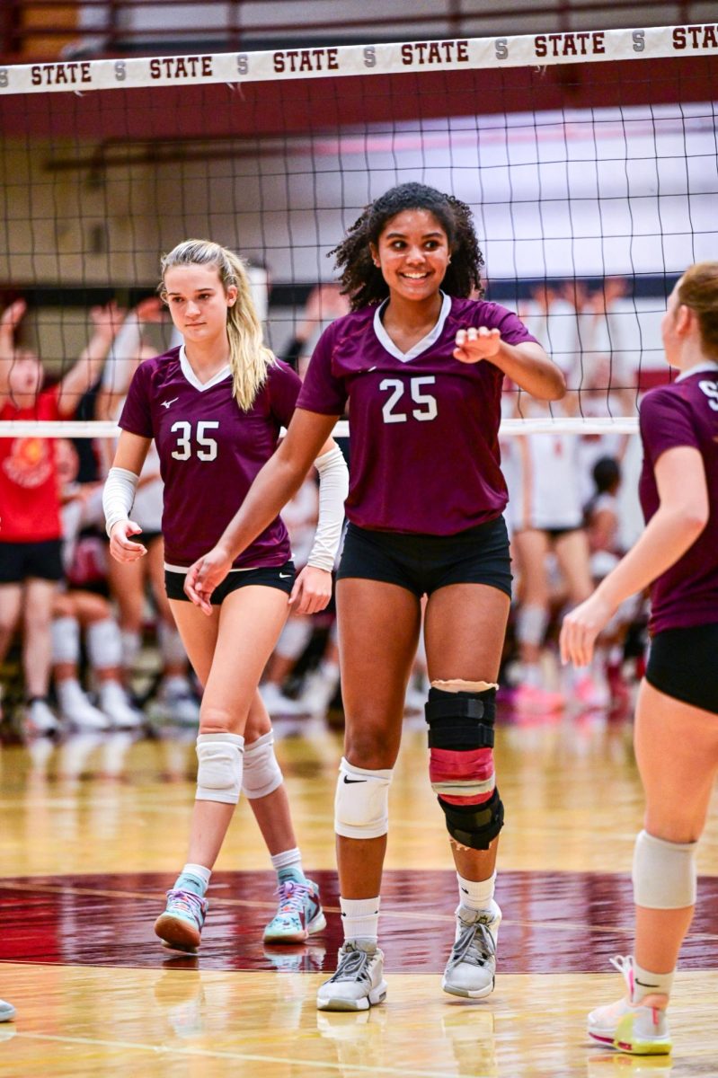 A SCAHS Girl's volleyball player reaches her hand out towards a teammate.