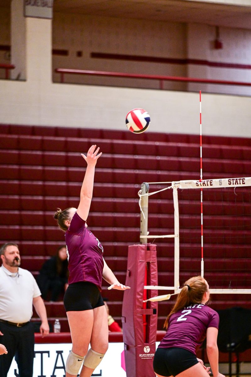 A SCAHS Girl's Volleyball player reaches up to return a hit.