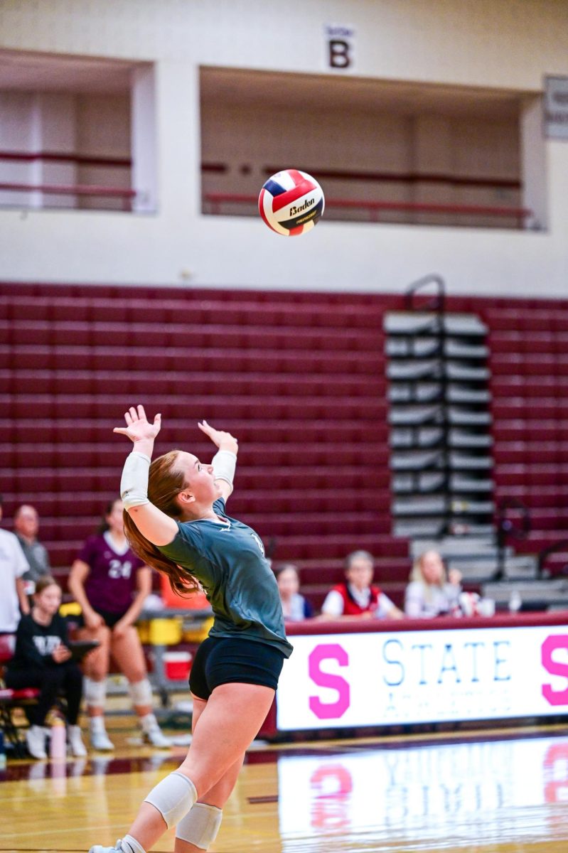 A SCAHS Girl's Volleyball Player serves the ball to the other team.