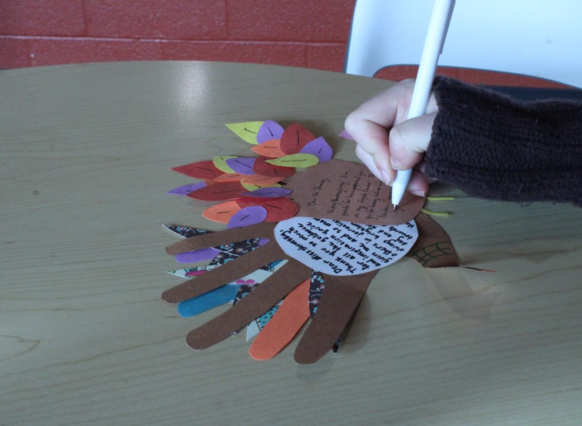 A student decorates a turkey for a teacher.