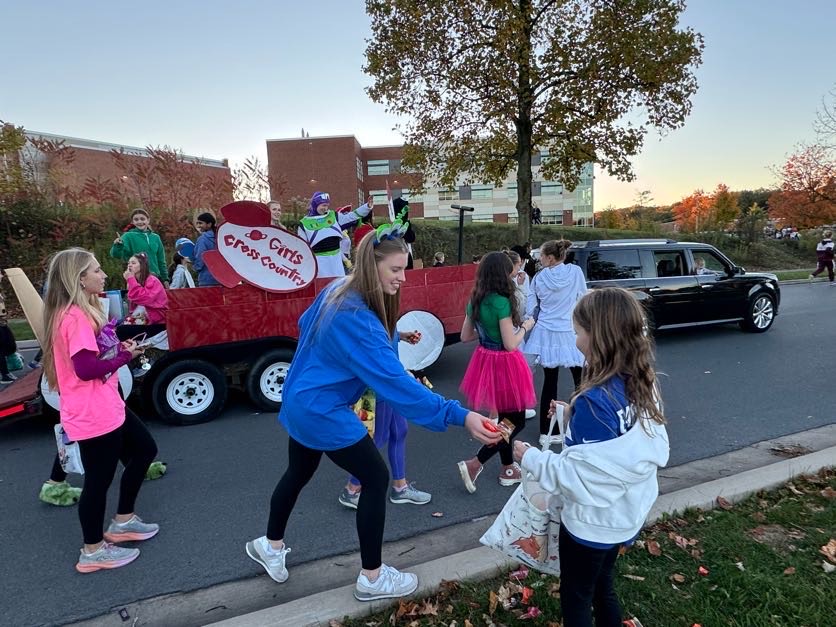 Molly Dell hands a girl a piece of candy at the Homecoming Parade. Courtesy of Julie Coughlin. 