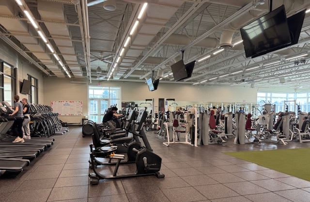 The State College High School Fitness Center being used during the school day. Two students are seen using the treadmills on the left along with another student using a bike.