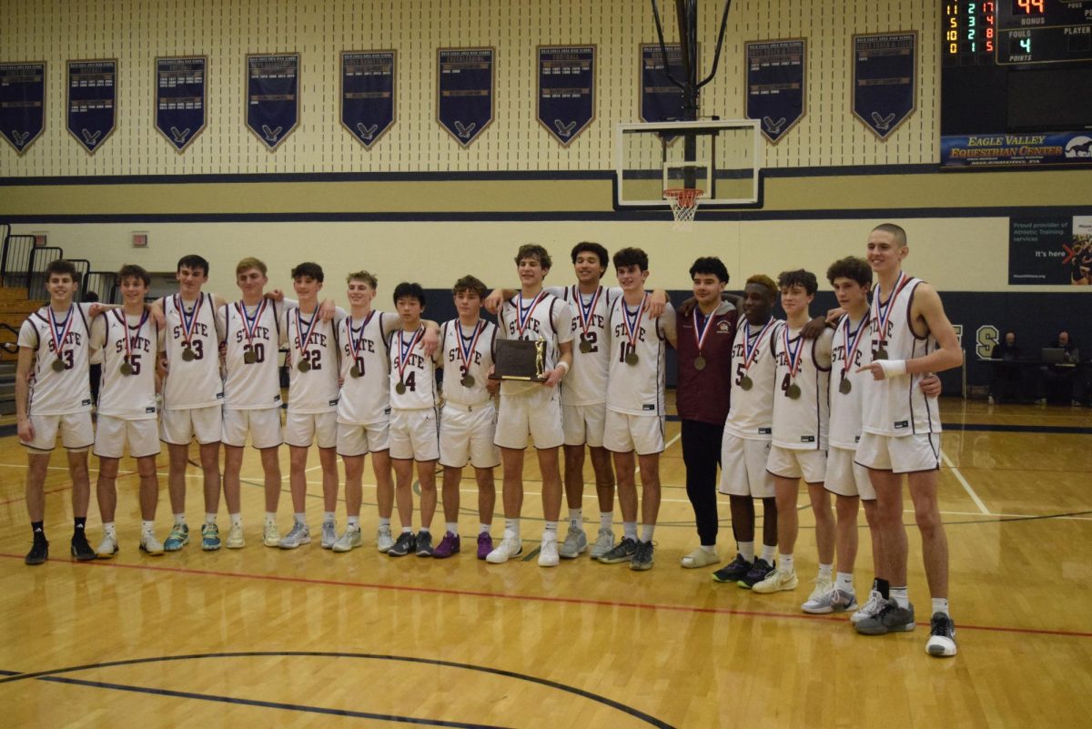 The State High Boy's team poses for a photo after their win with gold medals around their necks. Charlie Yartz holds the trophy in the middle.