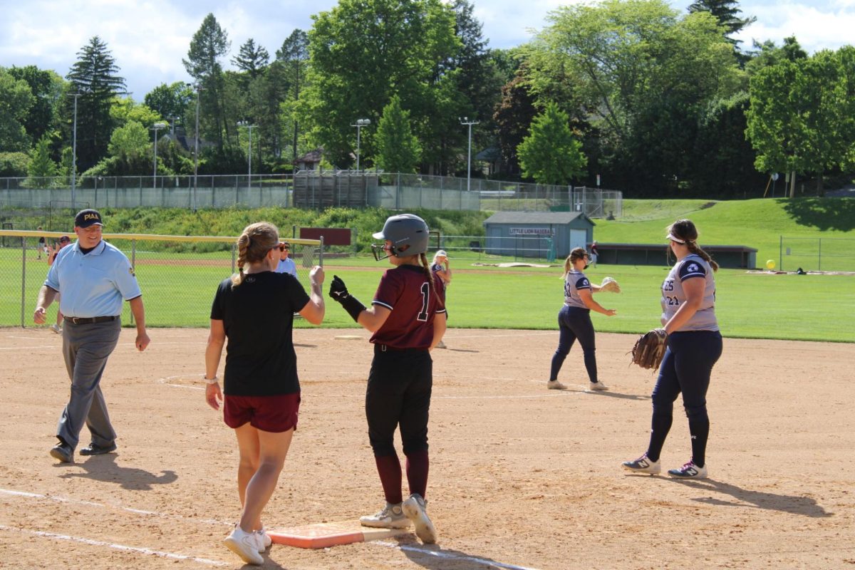 Coach Courtney Morrison gives a fist bump to Jessica Hawbaker at first base. 