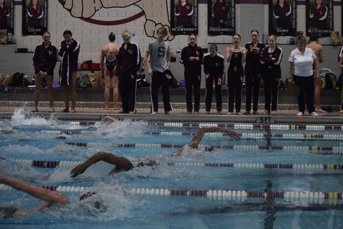 Members of the State High Swim Team cheer their teammates on as they compete in an event.