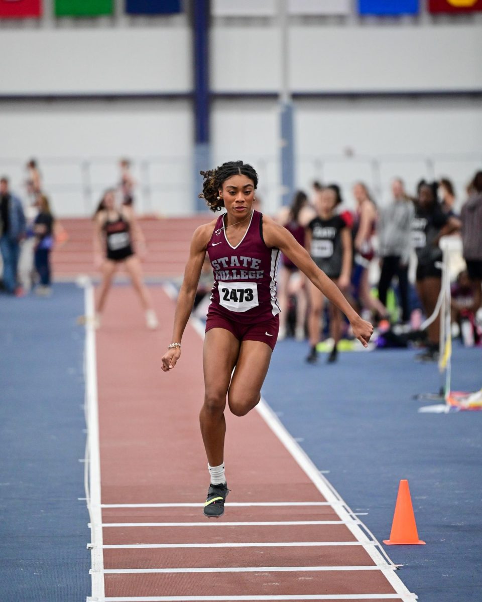 Sanai Abdullah jumps on an indoor track, not yet at the sand pit. She is wearing a State High track and field uniform, competing for the team in 2025.