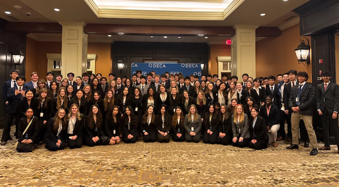 DECA members that qualified for states posing for a group picture in front of a DECA backdrop