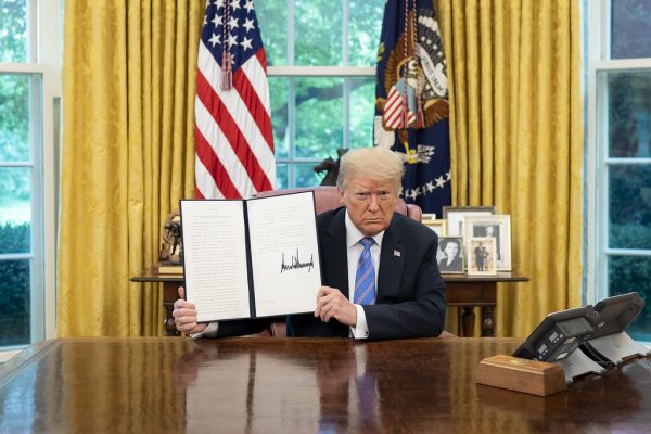 President Donald Trump signs an executive order during his 2020 presidency. Photo courtesy of the White House Flickr, accessed via public domain. 