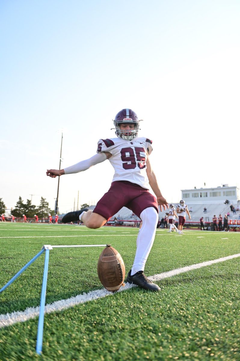 Sophomore Shane Markowski kicks a football during warm-ups for the 2024 game at Cumberland Valley.