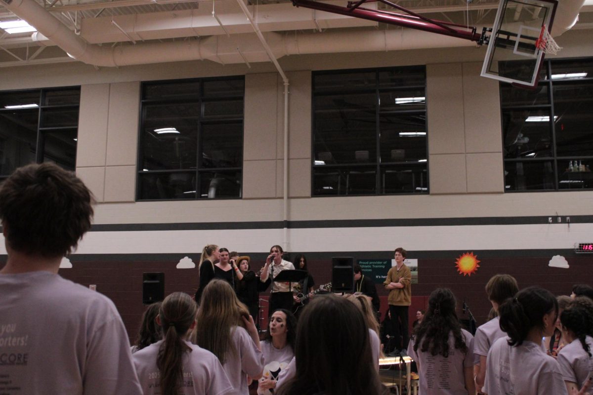 Students are dancing and singing along with the state high band performing.