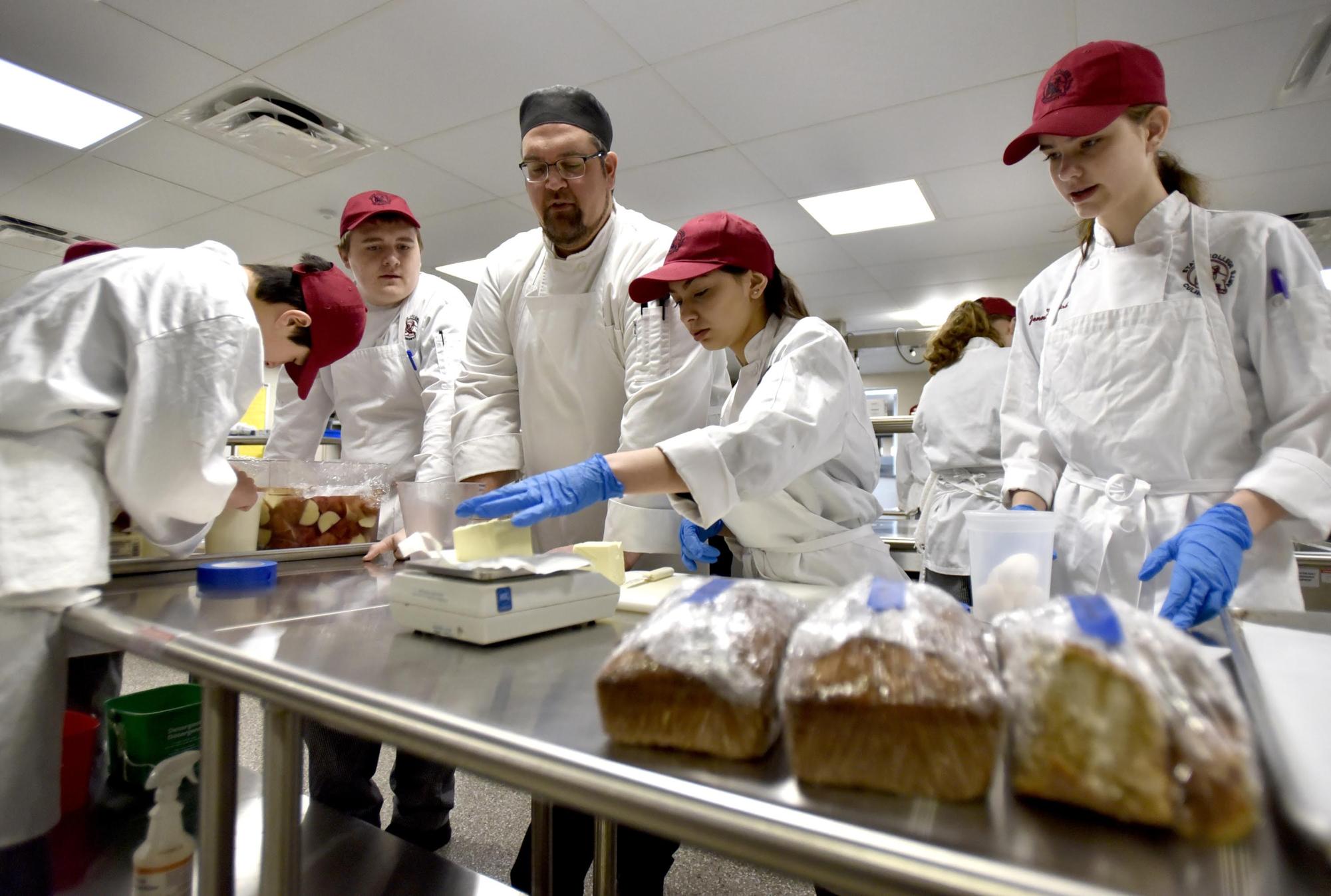 Culinary Arts Director Zach Lorber assists students during his class. Photo courtesy of Nabil Mark.