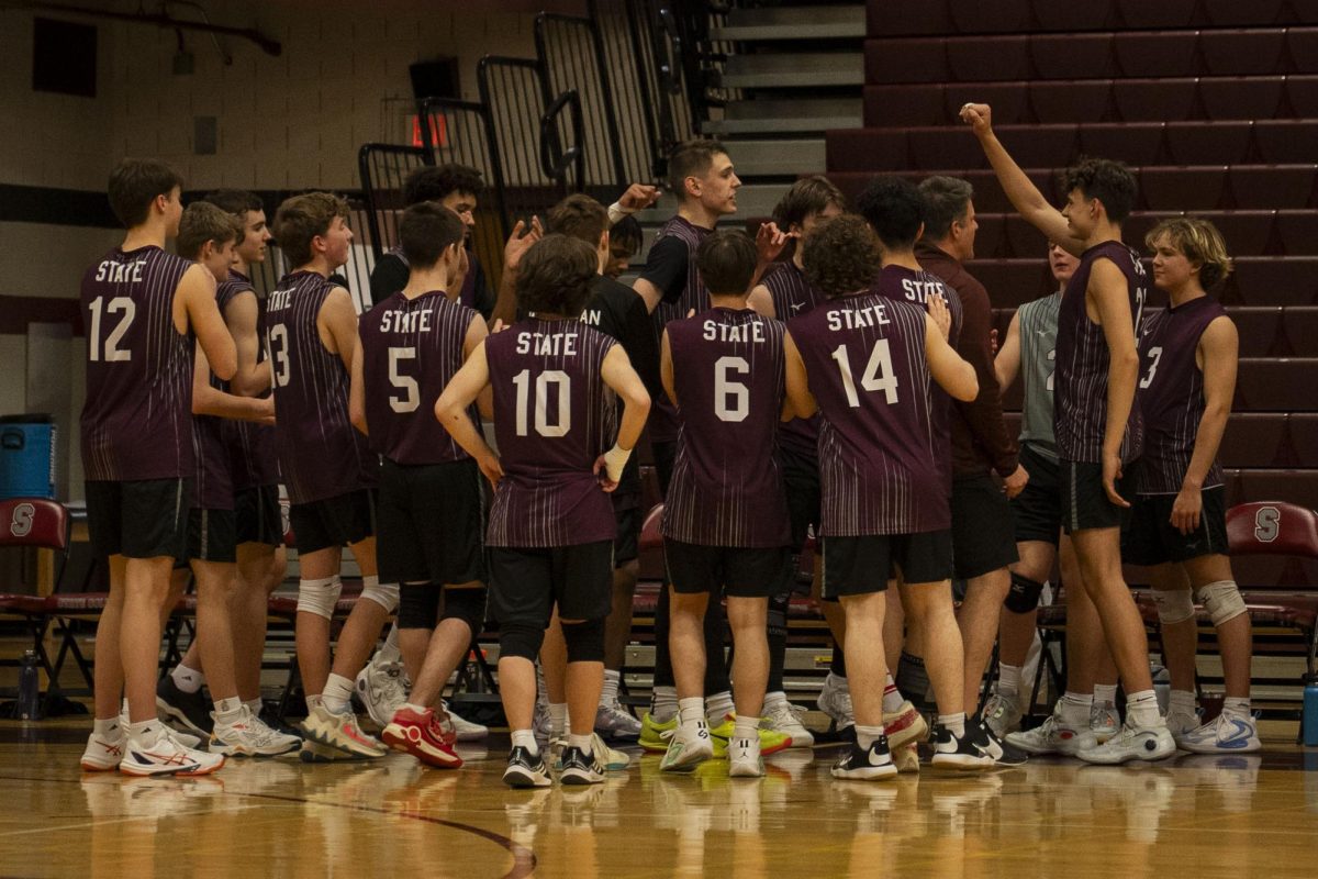 State High’s Boys Volleyball team comes together after a set win. The match is now tied, and tensions are high. 