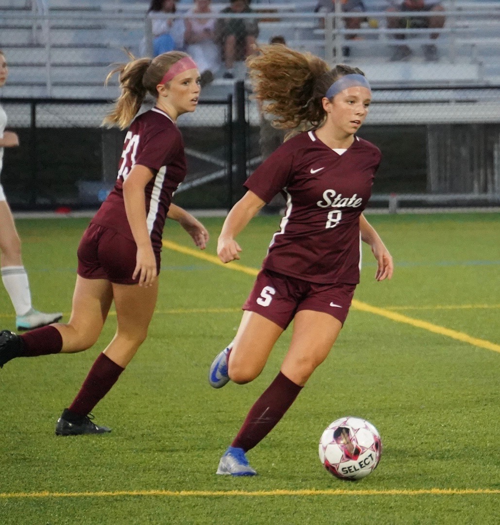 Sophomore Charlotte Bathgate runs alongside sister Ava Bathgate at a State High soccer match