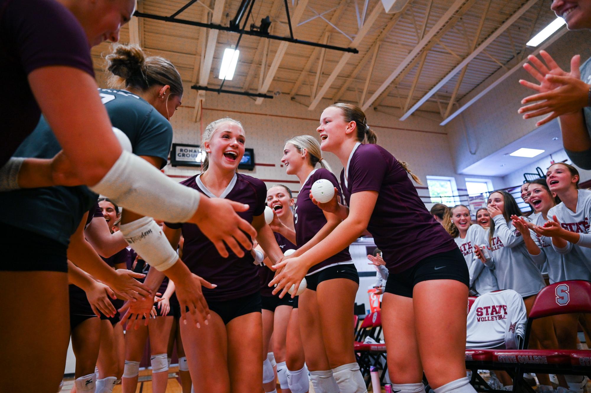 Junior Kenzie Kurzinger runs through a tunnel of teammates during starting lineups. This tunnel, yet another tradition, is a loud and exciting kickoff to the team's game. 
